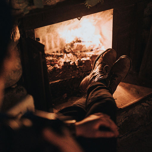 A person relaxing by the fireplace